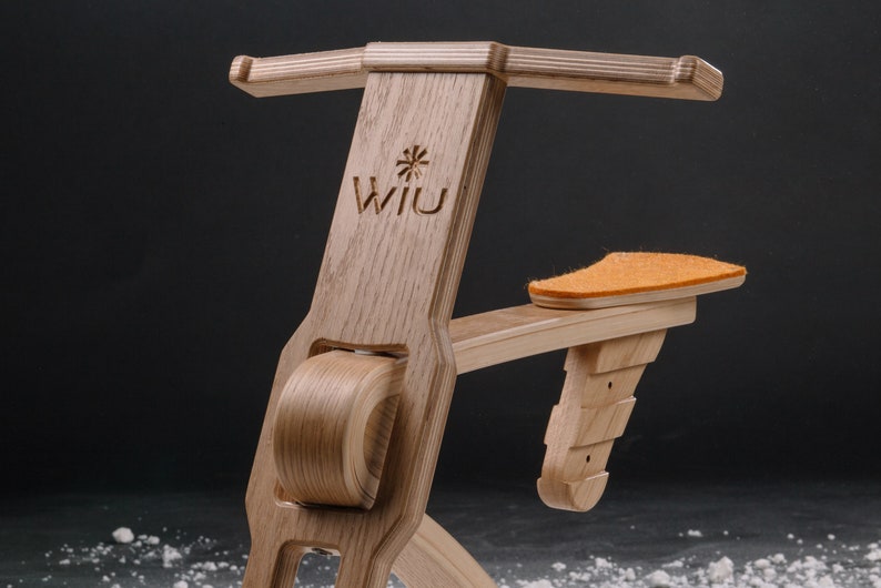 以下が含まれることがあります： 木製の自転車の形をしたおもちゃで、茶色の革製のシートと前面に「Wii U」という文字が刻まれています。