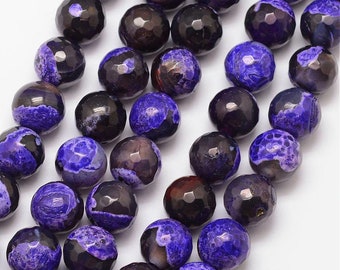 May include: Close-up of faceted, round beads in shades of deep purple and black. The beads have a marbled appearance with a polished finish. These beads are suitable for jewelry making, such as necklaces and bracelets.