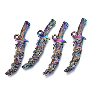 May include: Four iridescent dagger charms. Each charm features a dragon design on the handle and blade. The daggers have a loop at the top for attaching to jewelry. The colors include purple, green, blue, and gold.