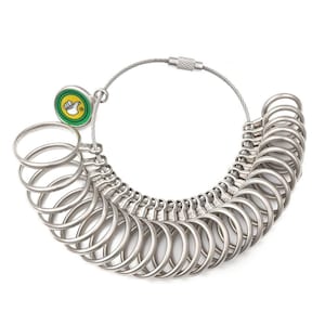 May include: A silver ring sizer tool with multiple metal rings of varying sizes, connected by a flexible wire. A small, round green and yellow logo is attached to the wire. The tool is designed for measuring ring sizes.