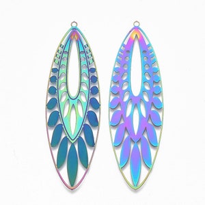 May include: Two iridescent, elongated pendant charms with intricate cut-out designs. The charms have a teardrop shape with a small loop at the top for hanging. The color shifts from blue to purple to green, creating a vibrant, eye-catching effect.