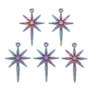 May include: Five iridescent star-shaped pendants with a central circular design and elongated points. Each pendant has a small loop at the top for hanging. The pendants display a range of colors, including purple, blue, green, and gold.