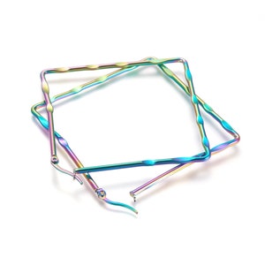 May include: A pair of iridescent square hoop earrings. The earrings have a twisted, textured design and a rainbow color scheme, with hues of blue, green, purple, and gold. The earrings are shown against a white background.