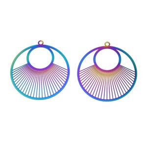 May include: Two iridescent fan-shaped earrings. Each earring features a large outer circle, a smaller inner circle, and a series of radiating lines. The earrings have a rainbow color gradient, transitioning from blue to purple and gold.