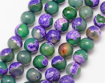 May include: Close-up of a strand of faceted gemstone beads. The beads are a mix of green and purple, with a marbled appearance. The beads are round and have a polished finish, ideal for jewellery making.