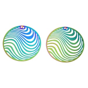 May include: Two iridescent, circular earrings with a wavy, striped pattern. The earrings have a small hole at the top for hanging. The colors shift from blue to green and yellow, creating a vibrant, eye-catching design.