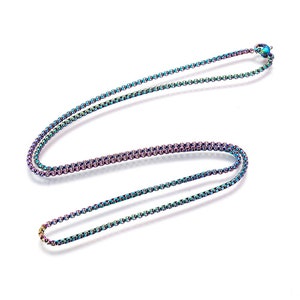 May include: A multi-colored necklace with a box chain design. The chain has a rainbow iridescent finish, with hues of blue, purple, and green. The necklace is displayed on a white background.