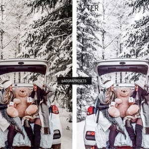 May include: Two people are sitting in the back of a white car with the trunk open. They are holding mugs and a large teddy bear. The car is parked in a snowy forest.