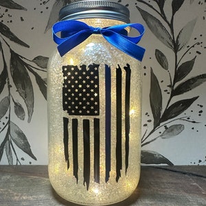 Thin blue line centerpieces. Black flag with blue line. Centerpiece with fairy lights and blue ribbon. police bulk rate