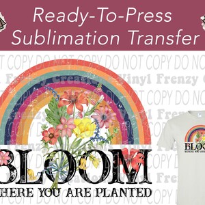 May include: A ready-to-press sublimation transfer design featuring a colorful rainbow arch with a bouquet of flowers. The design includes the words "BLOOM WHERE YOU ARE PLANTED" in a bold, black font. A t-shirt with the same design is also shown.