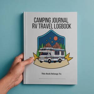 May include: A white camping journal with the text "CAMPING JOURNAL RV TRAVEL LOGBOOK" and a graphic of a camper van, trees, mountains, and a sun. The journal includes the text "This Book Belongs To" and a blank line.