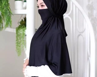 May include: A black hijab with a built-in face mask. The hijab is made of a soft, stretchy fabric and has a simple, elegant design.