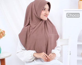 May include: A brown hijab with a pleated detail at the top. The hijab is worn by a person with a white shirt. The text "Choco" is visible in the upper right corner of the image.