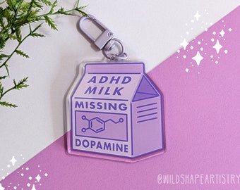 May include: Purple and white acrylic keychain shaped like a milk carton with the text "ADHD Milk Missing Dopamine" and a chemical structure diagram.