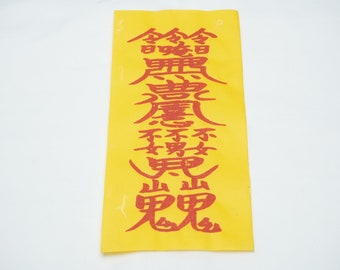 May include: A yellow paper with red Chinese characters printed on it. The characters read "金玉滿堂" which translates to "May your home be filled with gold and jade".