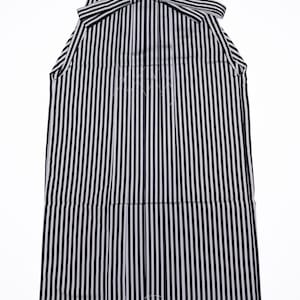 May include: A black and white striped hakama, a traditional Japanese garment. The hakama features vertical stripes, a pleated design, and a bow at the top. The garment is made of a lightweight fabric.