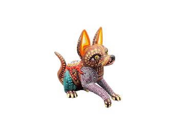 May include: A hand-carved wooden dog figurine in a resting pose, featuring intricate patterns and vibrant colors. The dog's body is adorned with geometric designs in shades of brown, red, blue, and purple, with yellow accents on the ears and paws.