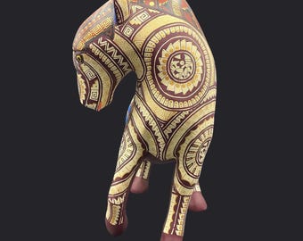 Puede incluir: Figura de caballo de madera hecha a mano con intrincados patrones en tonos marrón, dorado y rojo. El caballo presenta diseños geométricos detallados y motivos circulares, mostrando un estilo artístico único. La figura se apoya sobre cuatro patas con cascos granates.