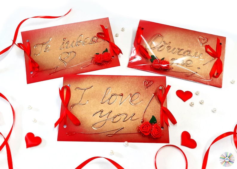 May include: Three red and gold Valentine's Day cards with different messages. The first card says "Te iubesc" with a heart and a red rose. The second card says "I love you!" with a red rose. The third card says "Obshcham tebe" with a red rose.