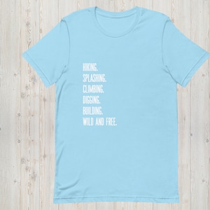 K&ouml;nnte beinhalten: Hellblaues T-Shirt mit dem Aufdruck "HIKING. SPLASHING. CLIMBING. DIGGING. BUILDING. WILD AND FREE." in Wei&szlig;.