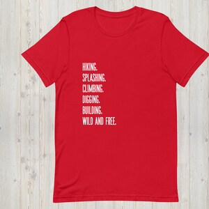 K&ouml;nnte beinhalten: Rotes T-Shirt mit wei&szlig;em Text, der "HIKING. SPLASHING. CLIMBING. DIGGING. BUILDING. WILD AND FREE." lautet.