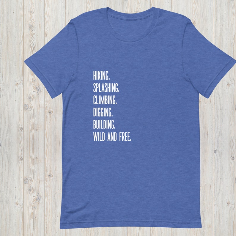 K&ouml;nnte beinhalten: Ein k&ouml;nigsblaues T-Shirt mit dem Text "HIKING. SPLASHING. CLIMBING. DIGGING. BUILDING. WILD AND FREE." in wei&szlig; gedruckt.