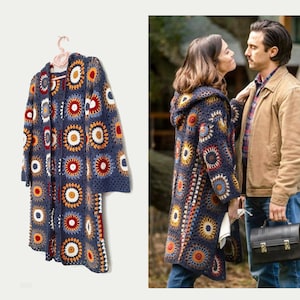 Könnte beinhalten: Ein langer, blauer Häkelcardigan mit Kapuze. Der Cardigan hat ein farbenfrohes geometrisches Muster mit roten, orangen, gelben und weißen Akzenten.