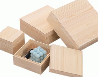 May include: Set of five unfinished wooden boxes in various sizes. The boxes are made of natural wood and have a smooth, unpainted surface. The largest box is open and contains a blue candle.