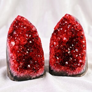 K&ouml;nnte beinhalten: Zwei rote Kristall-Geoden-Buchst&uuml;tzen. Jede Buchst&uuml;tze hat eine dunkelgraue Basis und ist mit funkelnden roten Kristallen gef&uuml;llt. Die Kristalle haben eine tiefe, satte rote Farbe und fangen das Licht ein, wodurch ein schillernder Effekt entsteht.