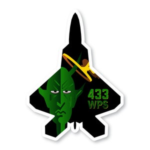 May include: A black and green sticker of a fighter jet with a green devil face on the left side and the text "433 WPS" on the right side.