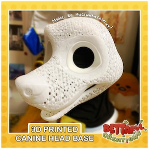 May include: A white 3D printed canine head base featuring a textured, lattice-like surface structure with large circular eye openings and a defined snout. The text "MODEL BY MUGIWARA COSPLAY!" is visible at the top, and "3D PRINTED CANINE HEAD BASE" is at the bottom.