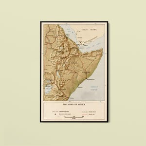 May include: A vintage-style map titled The Horn of Africa, featuring a beige and tan color palette. The map displays topographical details of Ethiopia, Somalia, Kenya, and surrounding regions, with a legend at the bottom showing international boundaries, railroads, and roads.