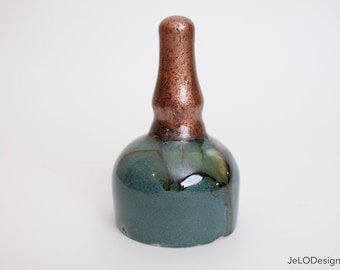 Small handmade green bell with a copper glazed handle