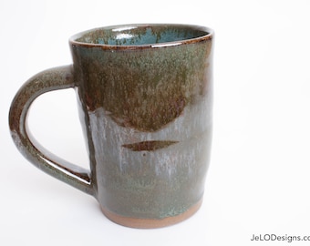 Deep green and copper adorn this large mug, inside is spruce green. Great for hot coffee, tea, cocoa or whatever beverages you like to drink