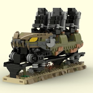 May include: A Lego model of a dark green and black roller coaster car with yellow eyes and teeth. The car is on a brown track and has three black seats.