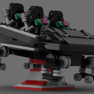 May include: Black Lego roller coaster car with three seats, green and pink accents, and black wheels. The car is on a red and white base.
