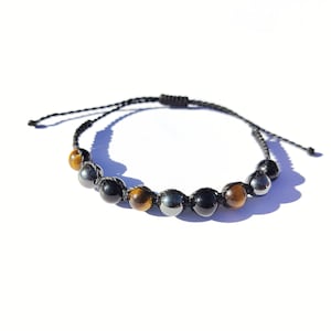 May include: Black string bracelet with tiger's eye and hematite beads.