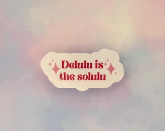 May include: A white sticker with the text "Delulu is the solulu" in red, with pink starburst accents. The sticker is on a pastel background of pink, blue, and purple.