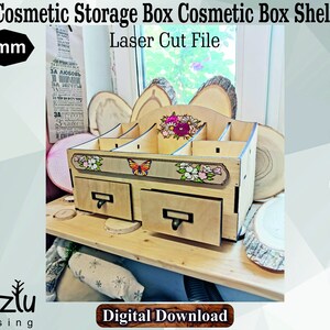 May include: Laser cut file for a wooden cosmetic storage box with two drawers and multiple compartments. The box is decorated with floral designs and a butterfly. The file is available in CDR, DXF, SVG, AI, EPS, and PDF formats. 6mm thick.