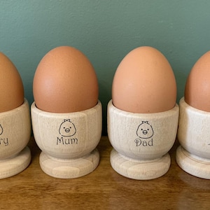 Juego de 4 hueveras de madera personalizadas con nombre grabado y la imagen de un pollito. Ideal para cumpleaños, Pascua, Navidad, Día de la Madre o del Padre, o como regalo familiar.