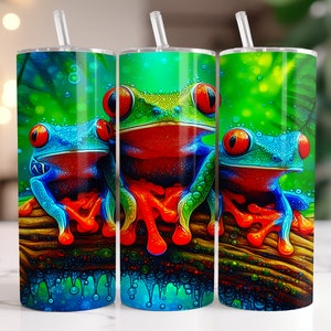 May include: Three colorful frog designs on a set of three stainless steel tumblers. The frogs are green, blue, and red with black eyes. The background is a green and brown jungle scene.