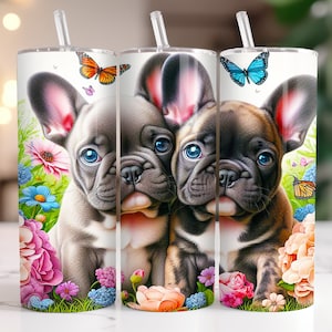 May include: Three stainless steel tumblers with a floral design and a French bulldog puppy on each. The tumblers are white with a clear lid and a straw.