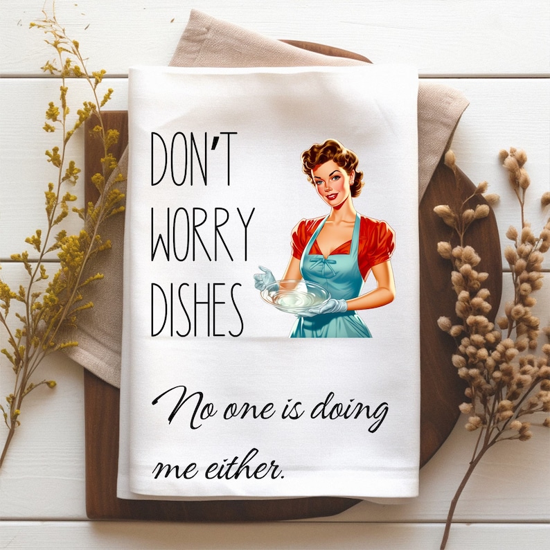 May include: White kitchen towel with a retro illustration of a woman holding a plate of dishes. The text reads "Don't worry dishes, No one is doing me either."