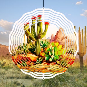 May include: A white metal wind spinner with a circular design featuring a colorful illustration of a desert landscape with cacti and mountains. The spinner has multiple layers of wavy lines.