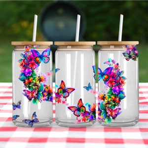 May include: Three clear glass tumblers with bamboo lids and straws. Each tumbler features a colorful butterfly and floral design.