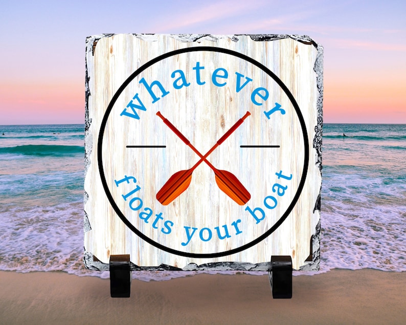 May include: A white wooden sign with a black circle and the text "whatever floats your boat" in blue. Two crossed orange paddles are inside the circle.