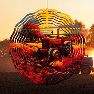 Op de afbeelding: Een rode metalen windmolen met een cirkelvormig ontwerp met een vintage tractor in een veld met herfstbladeren. De windmolen heeft meerdere lagen metaal die een wervelend effect creëren.