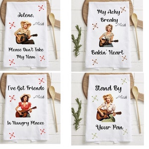 May include: Set of four kitchen towels featuring a vintage style illustration of a woman playing a guitar. Each towel has a different country music song lyric printed on it. The lyrics are "Jolene. Please Don't Take My Ham", "My Achy Breaky Bakin' Heart", "I've Got Friends In Hungry Places", and "Stand By Your Pan".