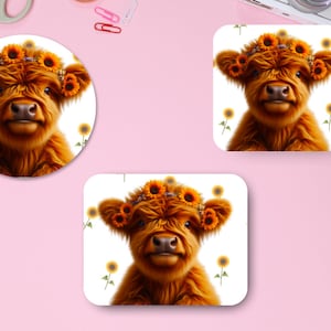 Könnte beinhalten: Ein süßes Highland-Rindkalb mit einer Sonnenblumenkrone. Das Kalb ist braun und flauschig vor weißem Hintergrund. Im Hintergrund sind Sonnenblumen zu sehen.