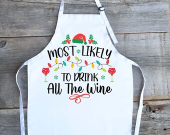 Könnte beinhalten: Weiße Weihnachts-Schürze mit roten, grünen und gelben Lichterketten, einer roten Weihnachtsmütze und dem Text "Most Likely To Drink All The Wine".
